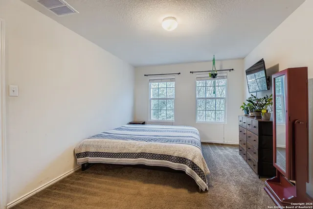 a spacious bedroom with a bed and a window
