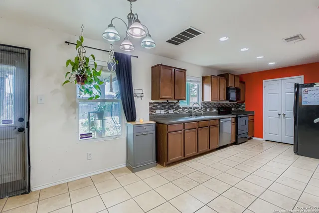 a kitchen with a refrigerator a stove top oven a sink and cabinets