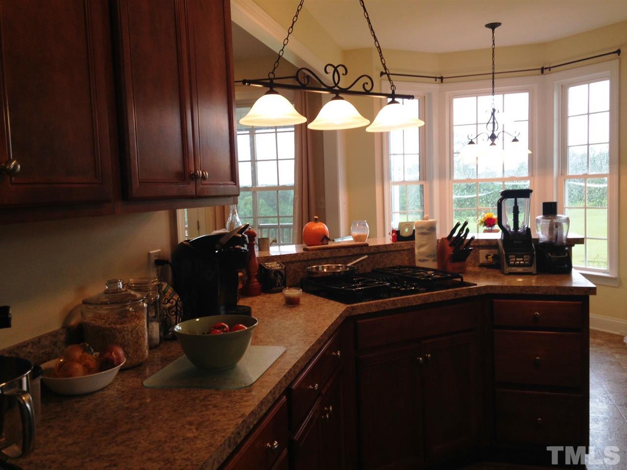 4678 Elevation Road Benson, NC 27504 - Photo 3 of 21 a kitchen with a sink a stove and a wooden floor