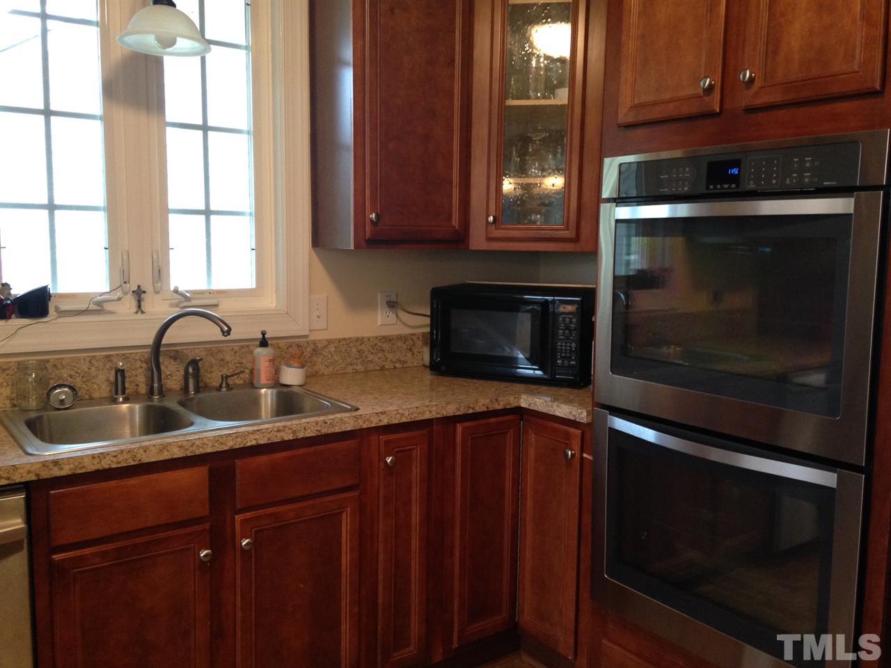 4678 Elevation Road Benson, NC 27504 - Photo 4 of 21 a kitchen with granite countertop wood cabinets and a stove top oven