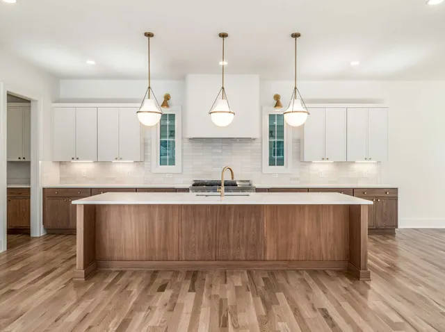 a large kitchen with kitchen island a large counter space a sink and appliances