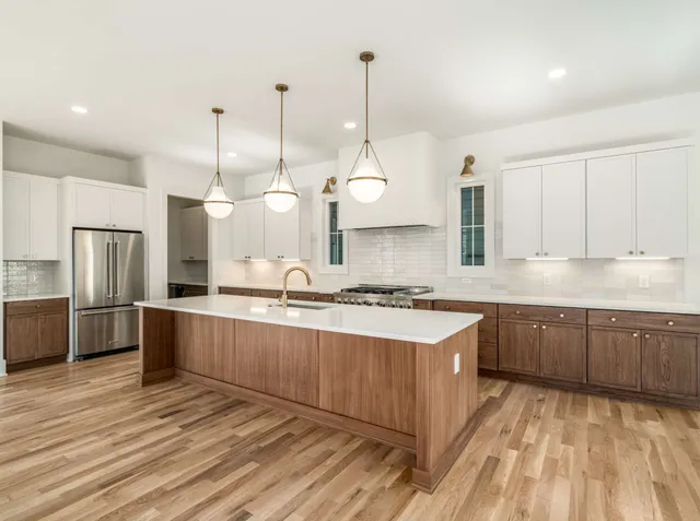 a large kitchen with kitchen island a sink stainless steel appliances and cabinets