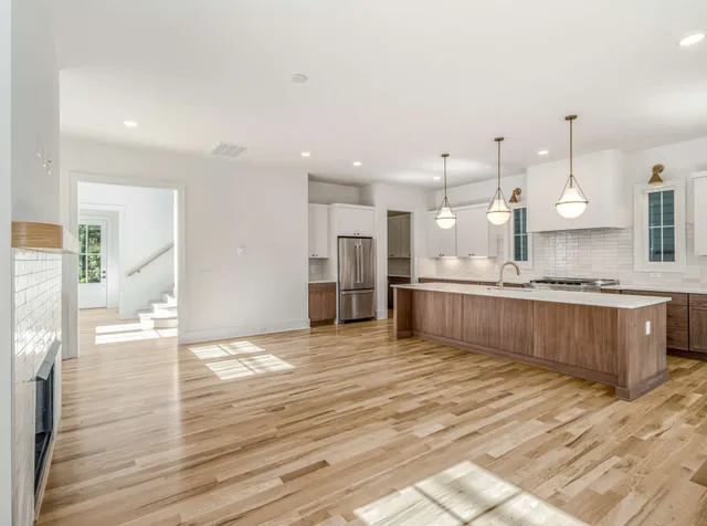 a large kitchen with kitchen island a sink stainless steel appliances and cabinets