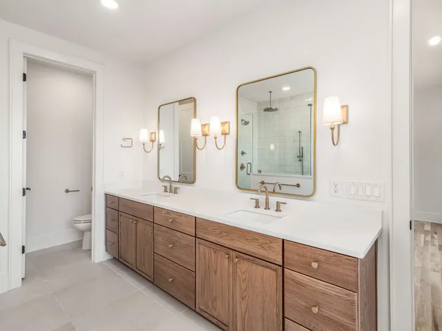 a bathroom with double vanity sinks and a mirror