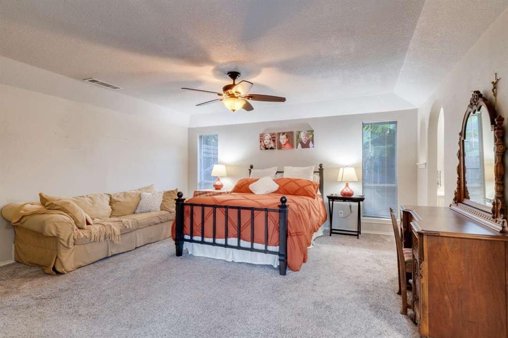 2628 Dalgreen Court Plano, TX 75075 - Photo 15 of 27 a bedroom with a bed a couch and a chandelier