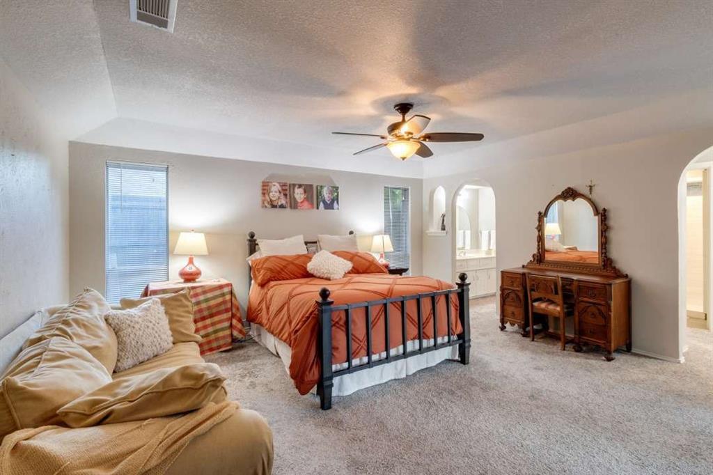 2628 Dalgreen Court Plano, TX 75075 - Photo 16 of 27 a bedroom with a bed and a chandelier