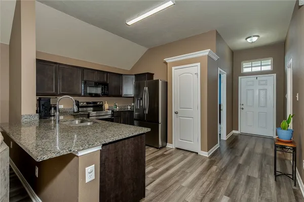 a kitchen with a refrigerator a sink a stove and cabinets