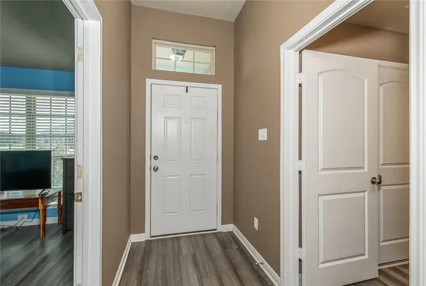 a view of a hallway with wooden floor and closet area