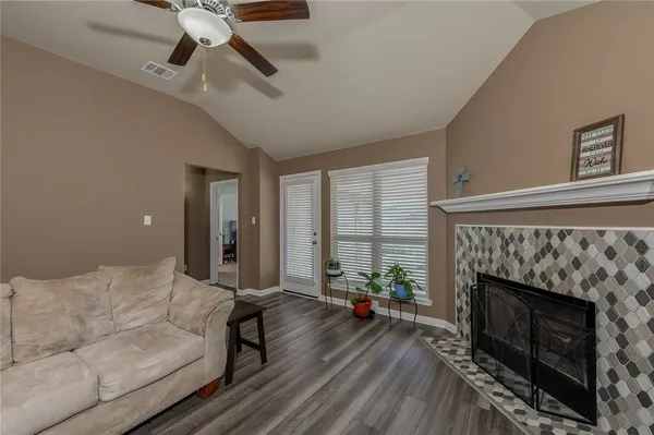 a living room with furniture a large window and a fireplace