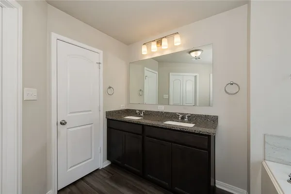 a bathroom with double sink and a mirror