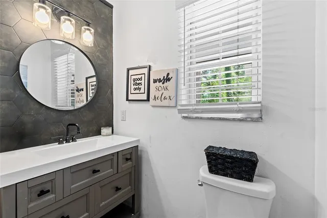 a bathroom with a toilet a sink and mirror