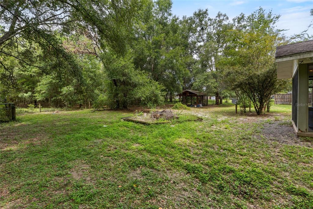 5309 Northeast 60th Avenue High Springs, FL 32643 - Photo 34 of 34 a backyard of a house with trees and outdoor seating