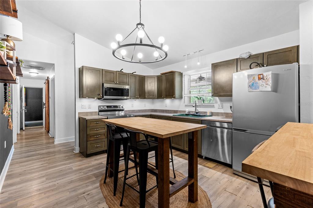 5309 Northeast 60th Avenue High Springs, FL 32643 - Photo 9 of 34 a kitchen with stainless steel appliances granite countertop a sink a stove a refrigerator cabinets and chairs