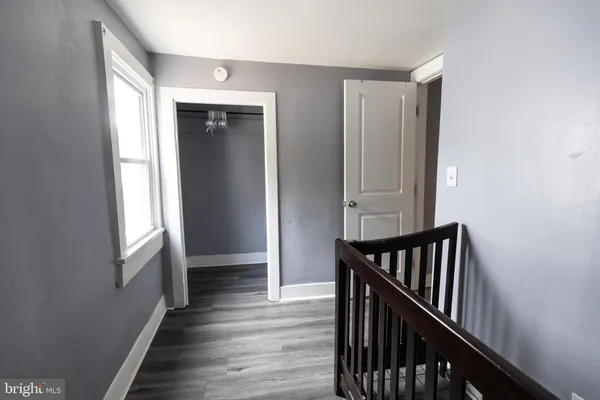 a view of a hallway with wooden floor and windows
