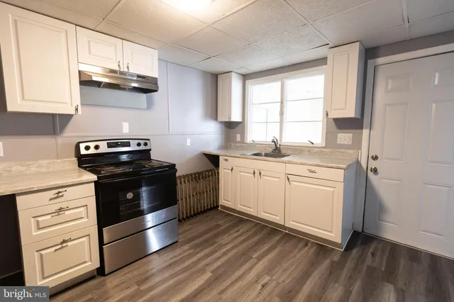 a kitchen with stainless steel appliances a stove a sink and a microwave