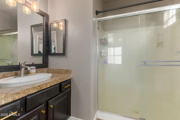 a bathroom with a granite countertop sink and a mirror