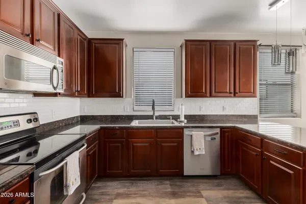 a kitchen with stainless steel appliances granite countertop a sink stove and cabinets