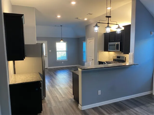 a kitchen with counter top space cabinets and appliances