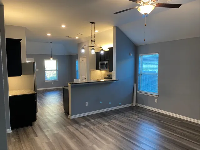 a view of a living room a room with wooden floor and chandelier