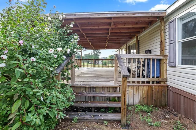 a view of a roof deck with chair and wooden fence