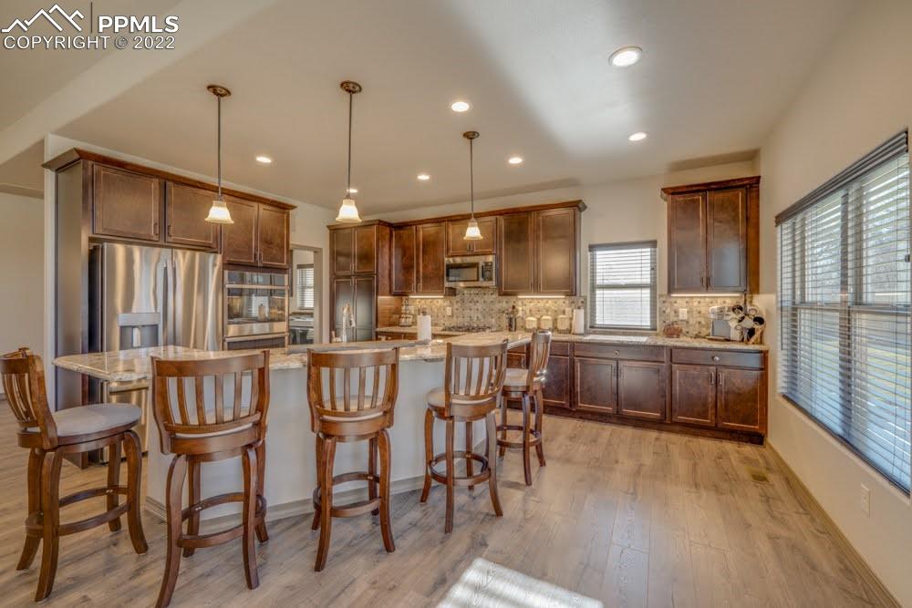119 Rocchio Drive Florence, CO 81226 - Photo 2 of 48 a kitchen with kitchen island granite countertop wooden floors and white cabinets