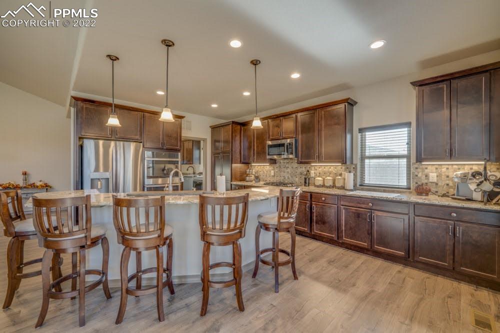 119 Rocchio Drive Florence, CO 81226 - Photo 28 of 48 a kitchen with stainless steel appliances kitchen island granite countertop a table chairs and a refrigerator