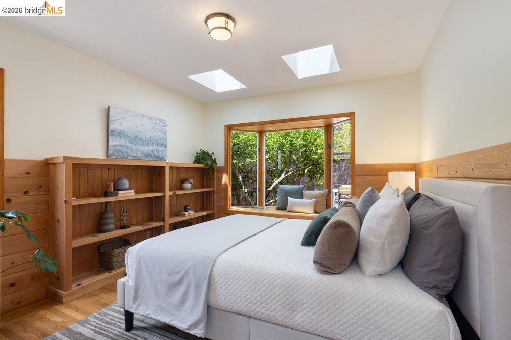 287 Purdue Avenue Kensington, CA 94708 - Photo 50 of 60 Wood-paneled room featuring a built-in window bench, two skylights, a built-in wooden bookcase, and wood-finish flooring