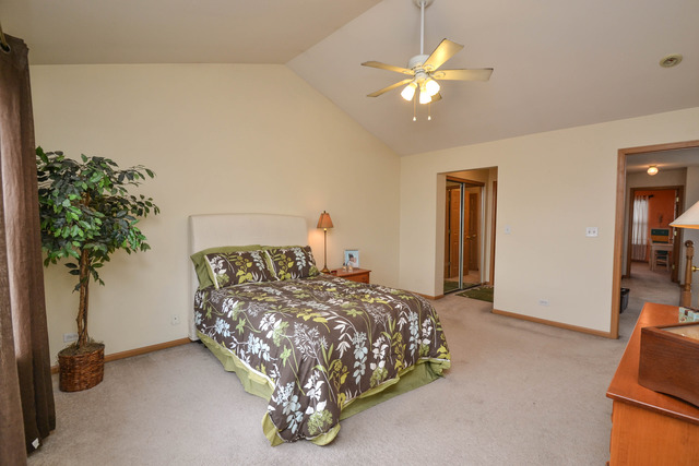 269 Grand Ridge Road, Unit 269 St. Charles, IL 60175 - Photo 13 of 25 a bedroom with a bed and a chandelier
