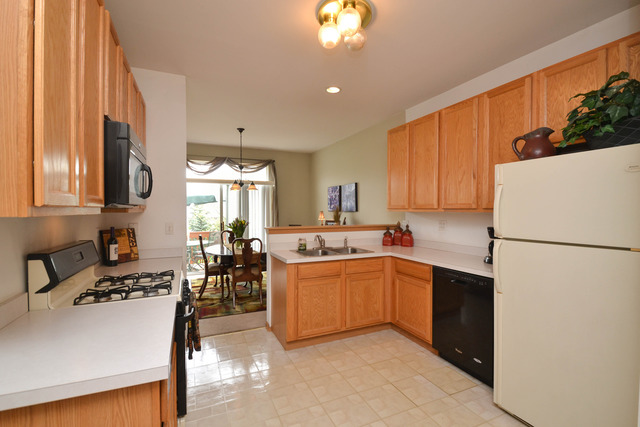 269 Grand Ridge Road, Unit 269 St. Charles, IL 60175 - Photo 7 of 25 a kitchen with a sink a kitchen island a stove and a refrigerator
