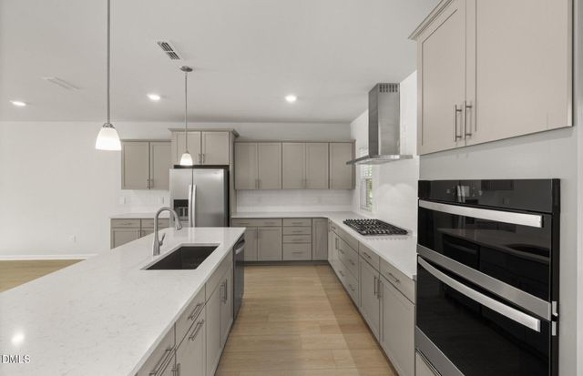 a kitchen with refrigerator and white cabinets