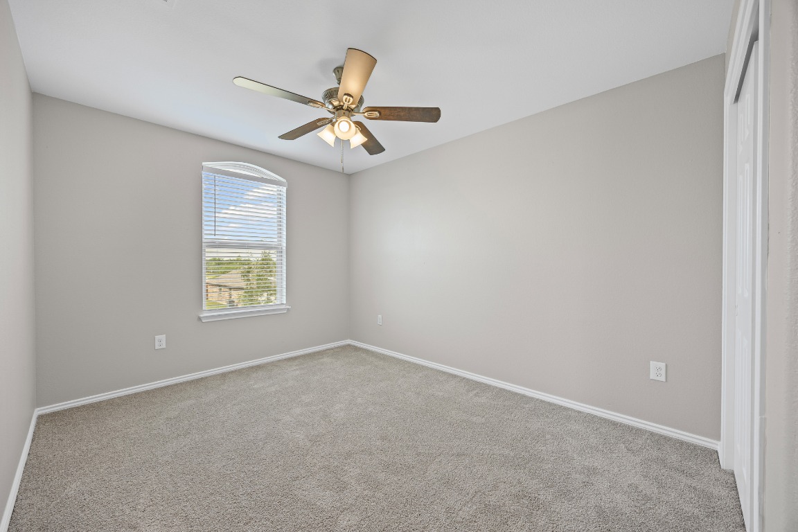 139 Diamondback Cove Buda, TX 78610 - Photo 10 of 15 an empty room with a window and a fan