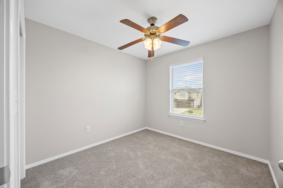 139 Diamondback Cove Buda, TX 78610 - Photo 11 of 15 an empty room with a window and a fan