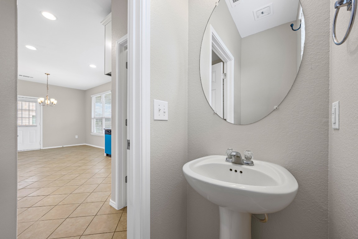 139 Diamondback Cove Buda, TX 78610 - Photo 12 of 15 a bathroom with a sink a mirror and a shower