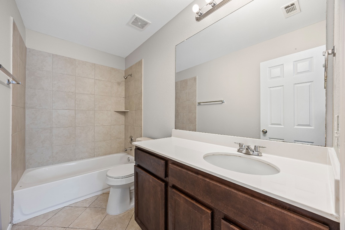 139 Diamondback Cove Buda, TX 78610 - Photo 14 of 15 a bathroom with a sink a toilet a bathtub and shower