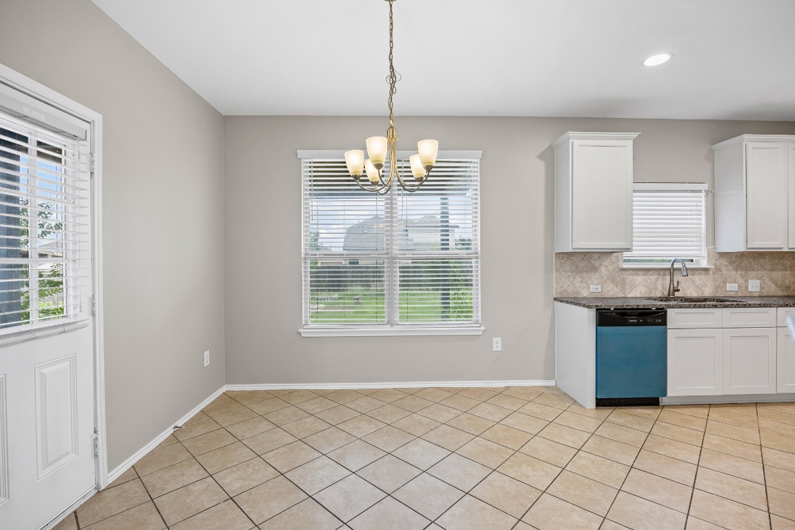 139 Diamondback Cove Buda, TX 78610 - Photo 5 of 15 a large kitchen with granite countertop white cabinets and a large window