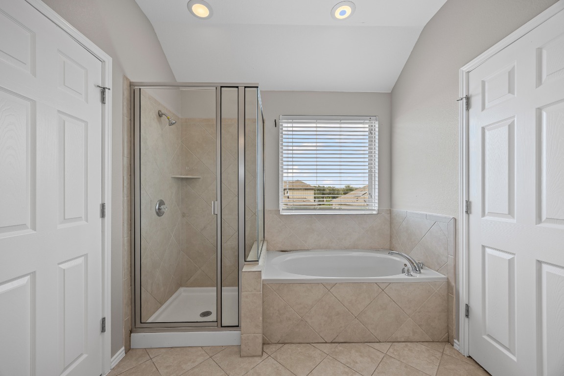 139 Diamondback Cove Buda, TX 78610 - Photo 9 of 15 a bathroom with a tub shower and window