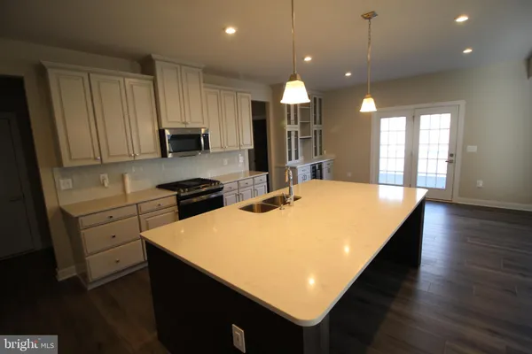a large kitchen with kitchen island a sink stainless steel appliances and cabinets