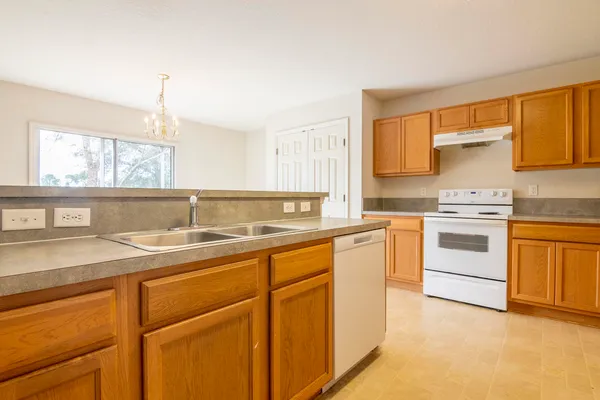 a kitchen with stainless steel appliances granite countertop a stove a sink and a microwave