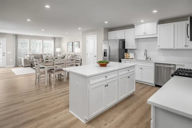 a kitchen with a sink microwave cabinets and dining table