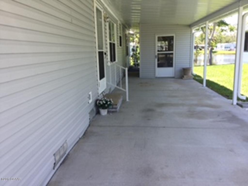 738 Navigators Way Edgewater, FL 32141 - Photo 2 of 16 a view of an entryway with wooden door and seating space