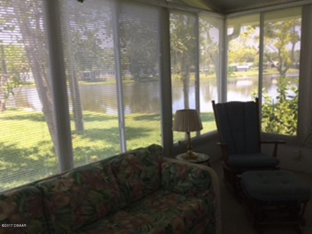 738 Navigators Way Edgewater, FL 32141 - Photo 4 of 16 a living room with furniture and a floor to ceiling window