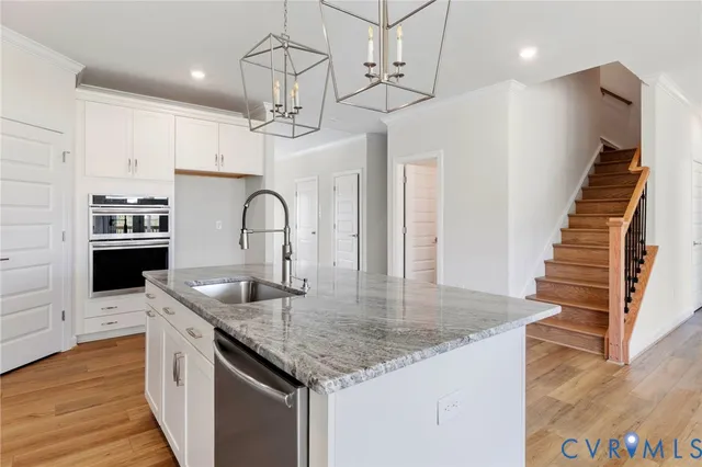 a kitchen with stainless steel appliances granite countertop a sink a stove top oven a counter space and cabinets