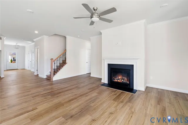 a view of an empty room with wooden floor a fireplace and a window