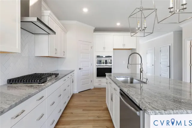 a kitchen with stainless steel appliances granite countertop a sink stove and cabinets