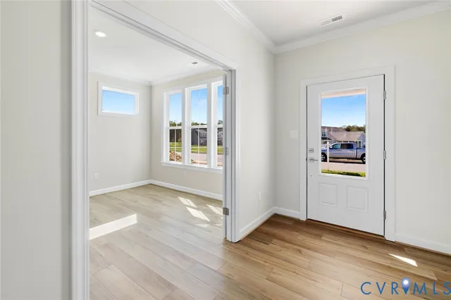 a view of a hallway with wooden floor and a kitchen