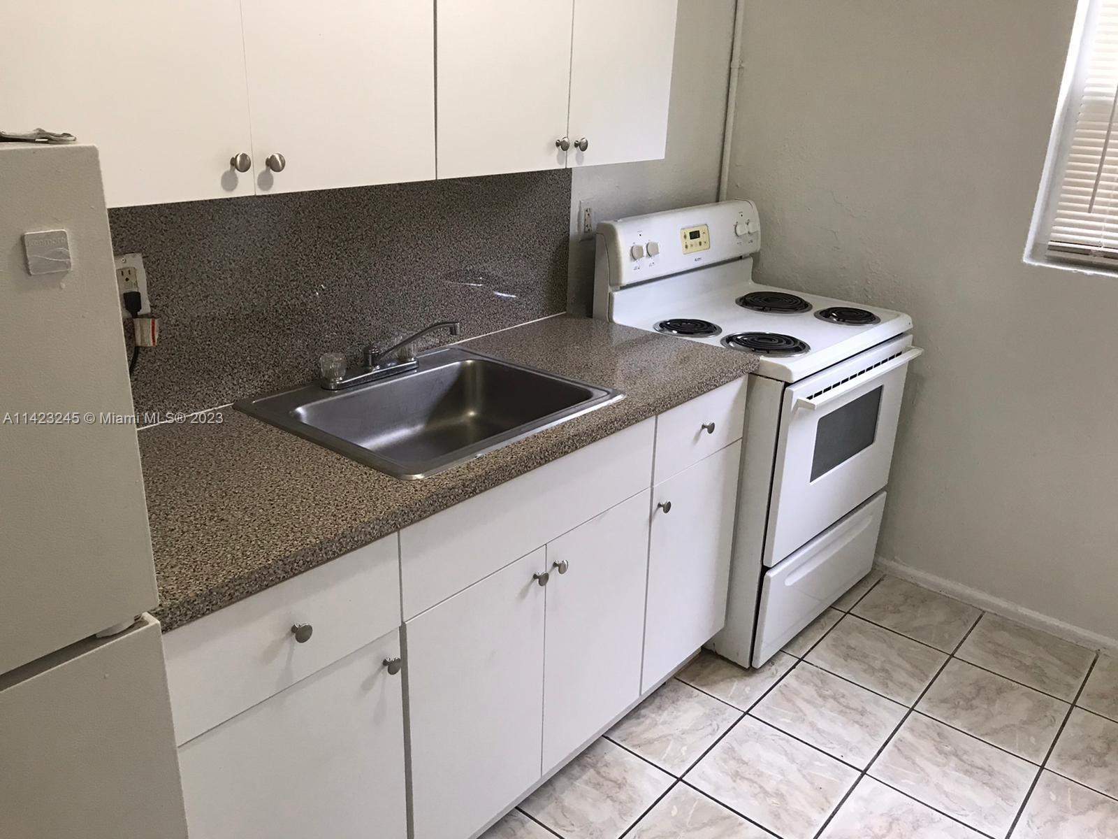 a kitchen with granite countertop a sink and a stove