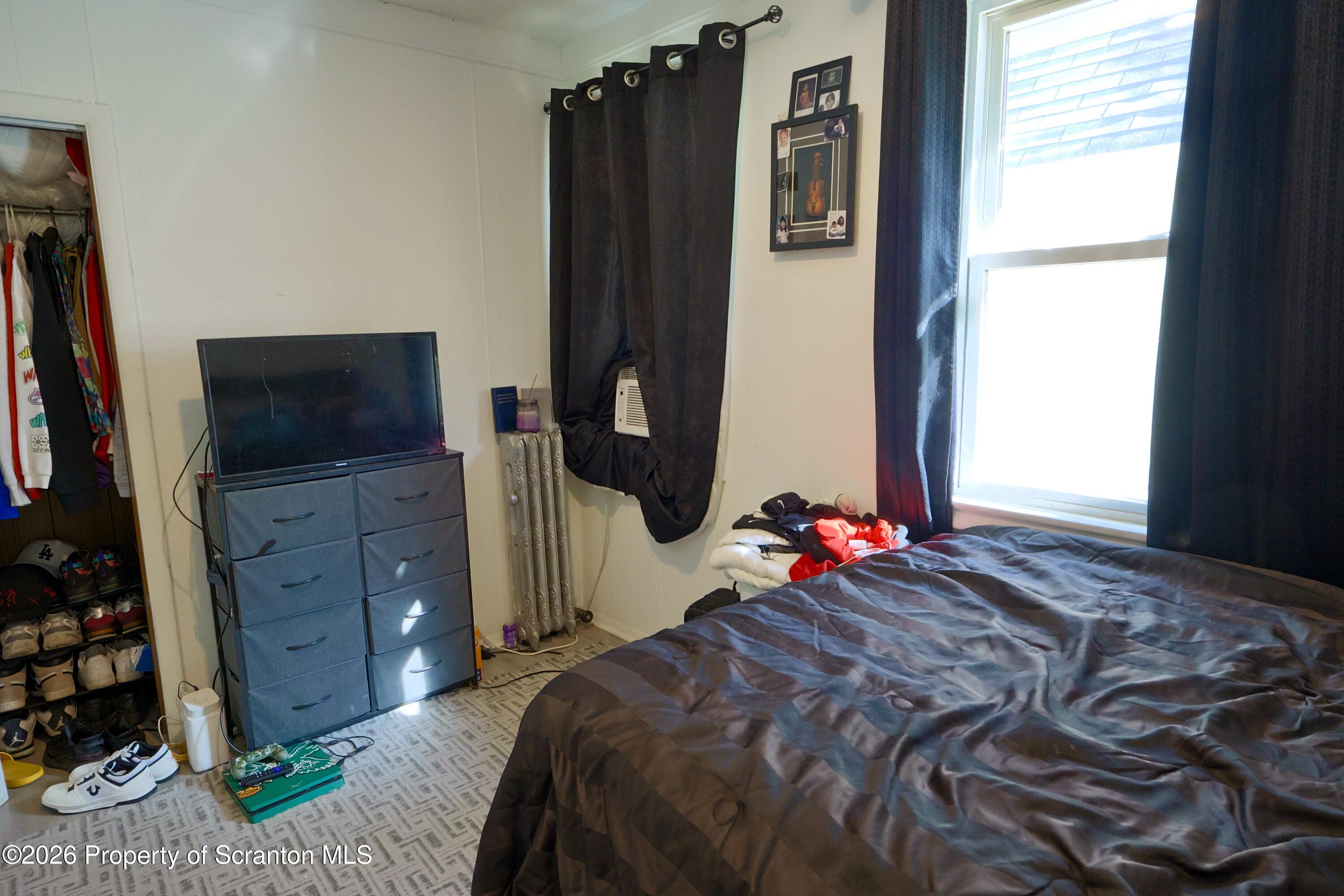 1016-1018 Diamond Avenue Scranton, PA 18508 - Photo 12 of 15 a bedroom with a bed closet and flat tv screen