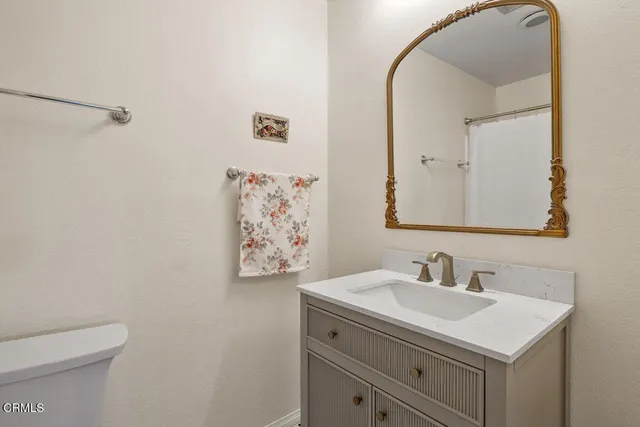 a bathroom with a sink mirror vanity and toilet