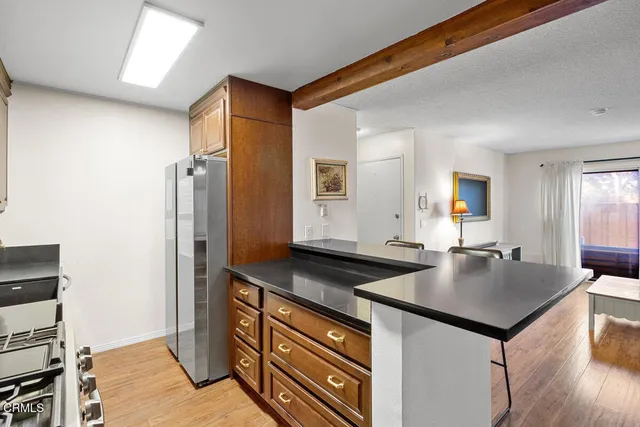 a kitchen with granite countertop a sink and refrigerator