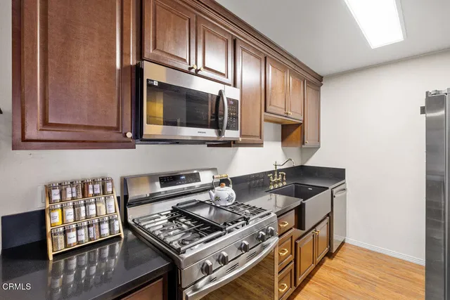 a kitchen with stainless steel appliances granite countertop a stove and a microwave